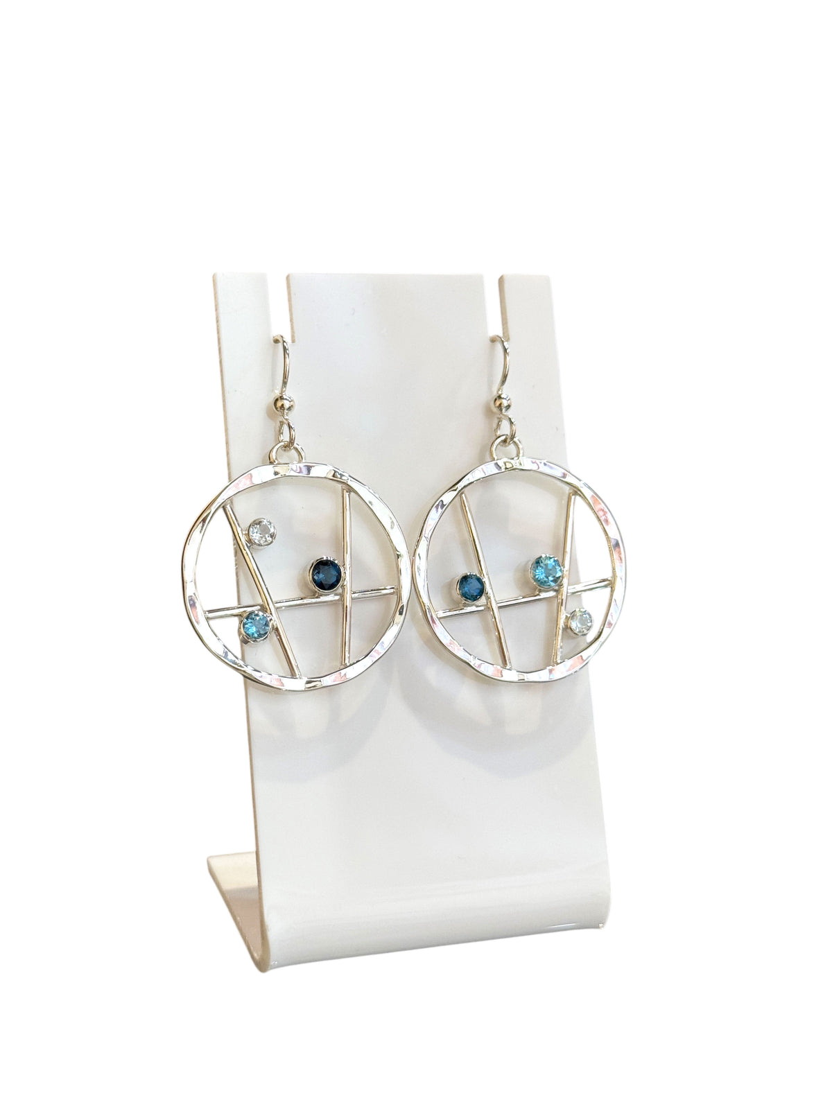 Small hammered sterling silver hoop earrings set with three shades of blue topaz