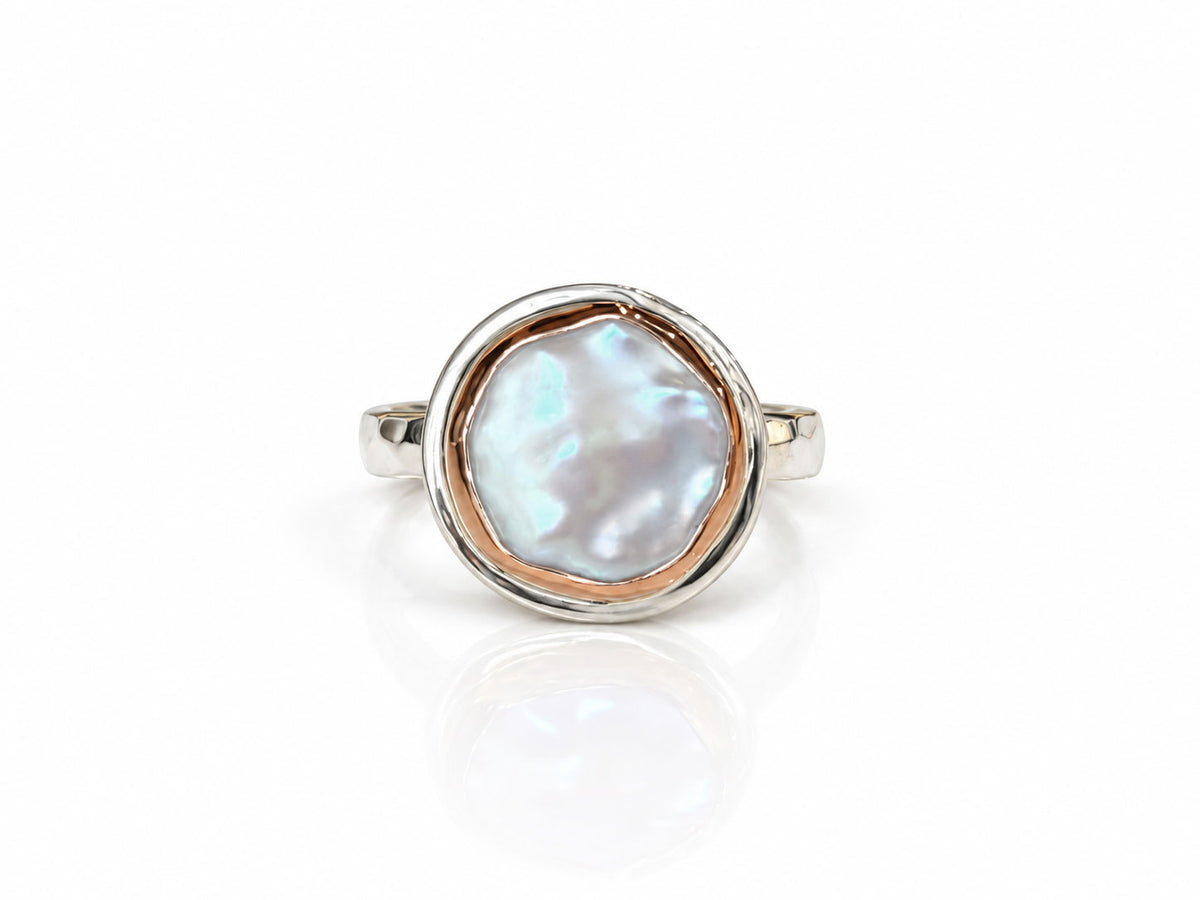 Creamy white freshwater coin pearl ring in a 14kt rose gold bezel on a sterling silver band