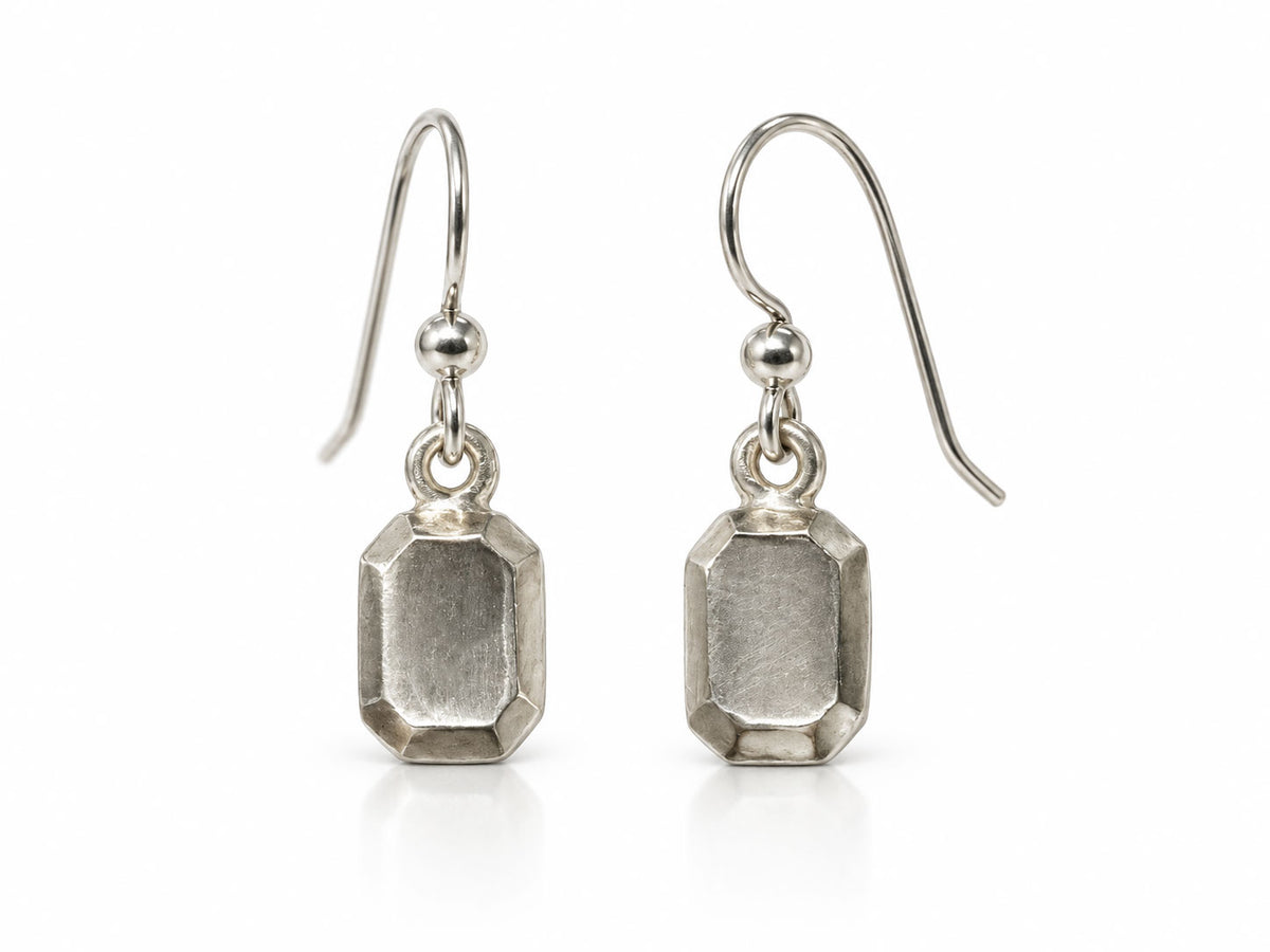 Sterling silver dangle earrings sculpted like emerald step-cut gems with brushed facets, on French wires