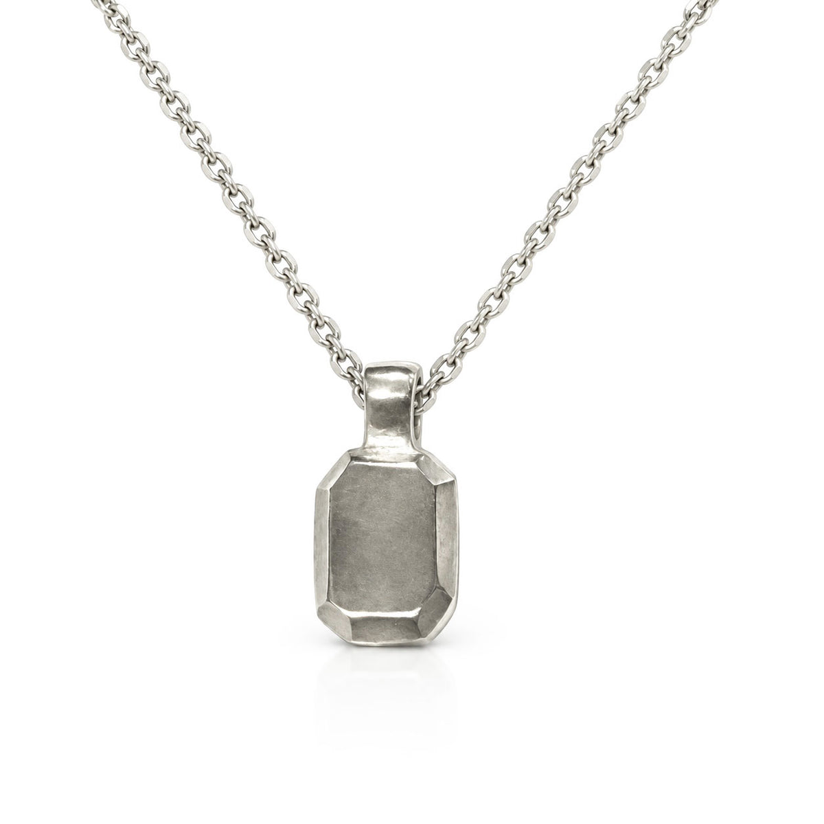 Sterling silver pendant sculpted like an emerald step-cut gem with brushed facets, on a delicate cable chain