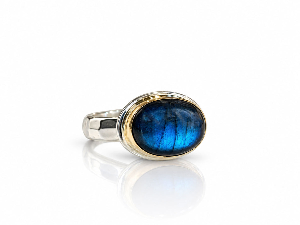 Oval labradorite with a royal blue flash in a 14kt yellow gold bezel on a sterling silver ring