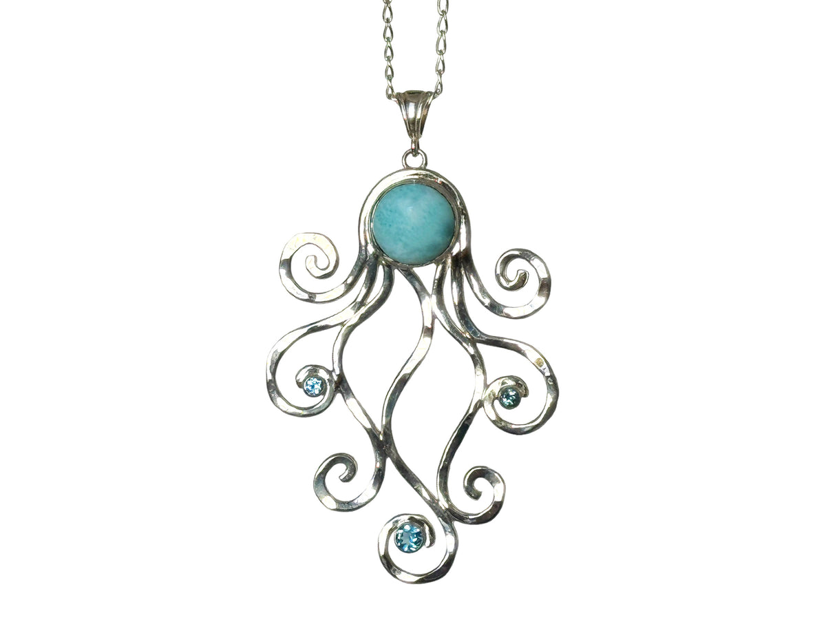 Sterling silver octopus pendant with a Caribbean larimar head and silver tentacles wrapped around faceted blue topaz