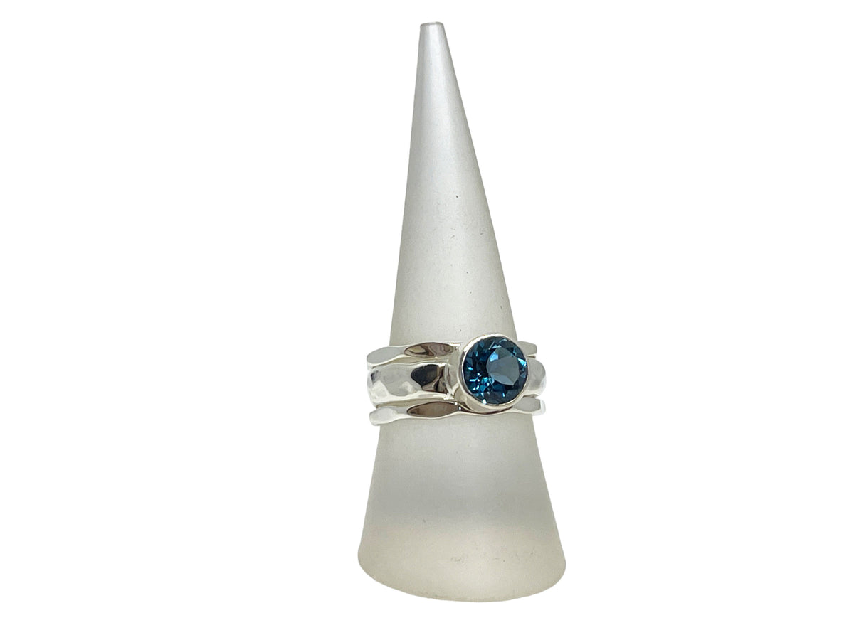 Close-up of the deep greenish-blue London blue topaz in its silver setting
