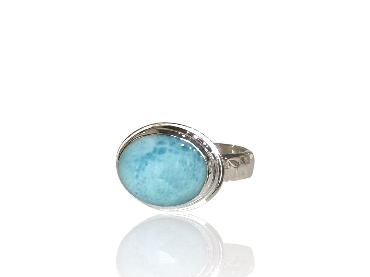 Oval Caribbean larimar cabochon set sideways in a shiny bezel on a 4mm hammered sterling silver band