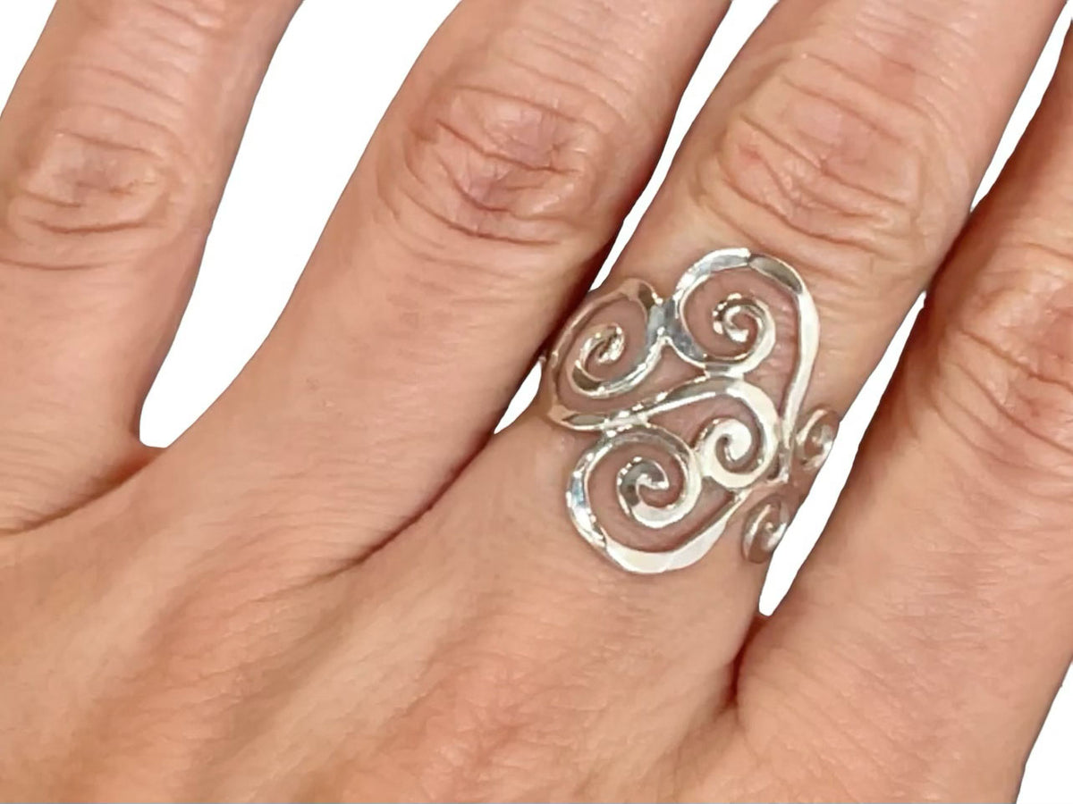 Alternate view of the hammered sterling silver swirl ring catching the light