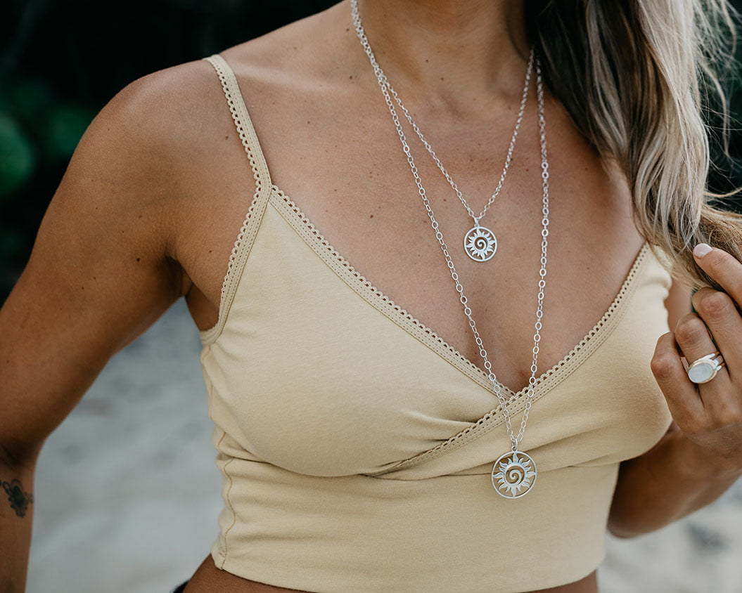 Silver sun swirl medallion necklace shown on its chain