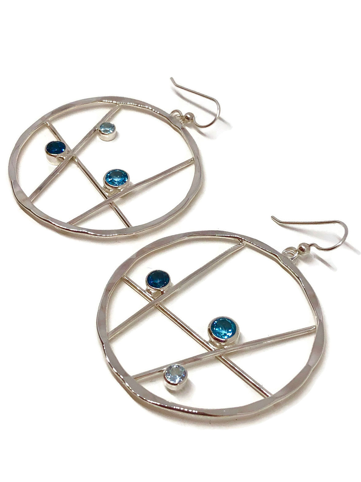 Close view of a hammered silver hoop with three shades of sparkling blue topaz
