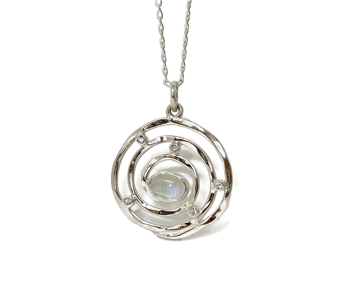 Silver Eye of the Storm pendant on its chain, inspired by the calm center of a hurricane