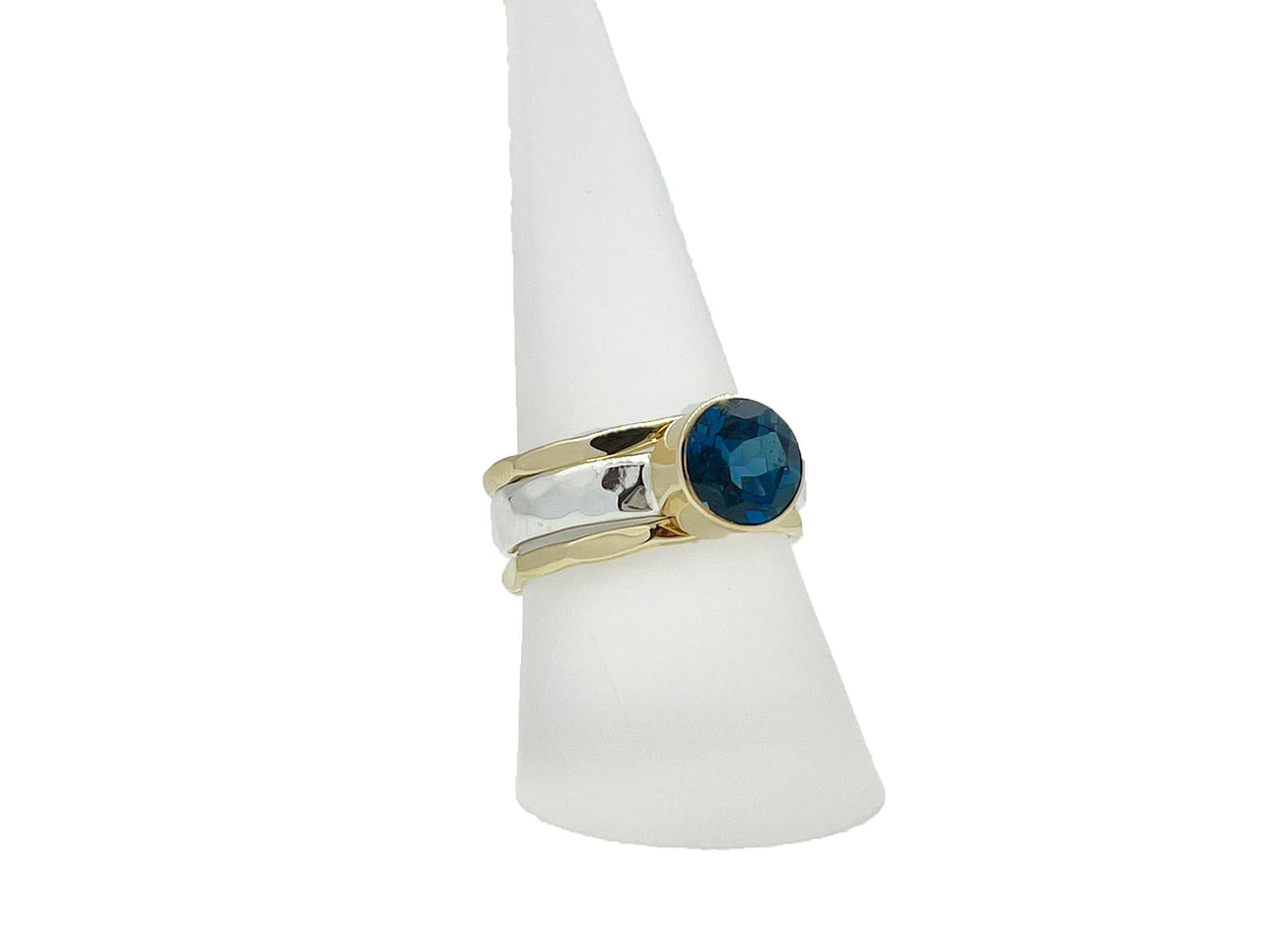 Side view of the London blue topaz ring with its hammered silver stack bands