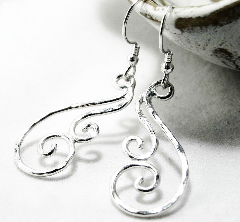 Side view of the lightweight silver swirl dangle earrings on ear wires