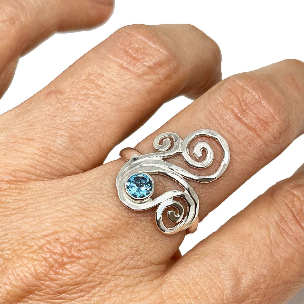 Alternate view of the silver swirl ring with blue topaz