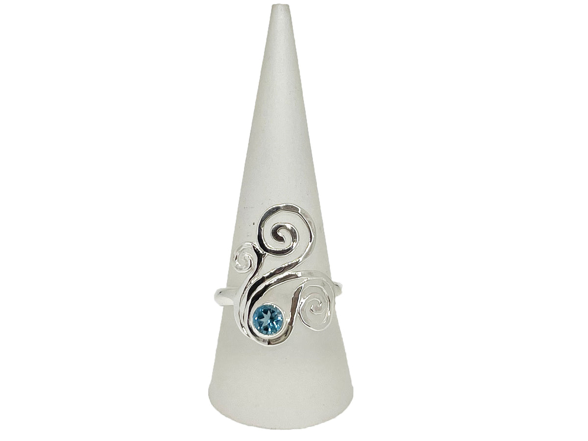 Side view of the rolling silver waves on the blue topaz swirl ring