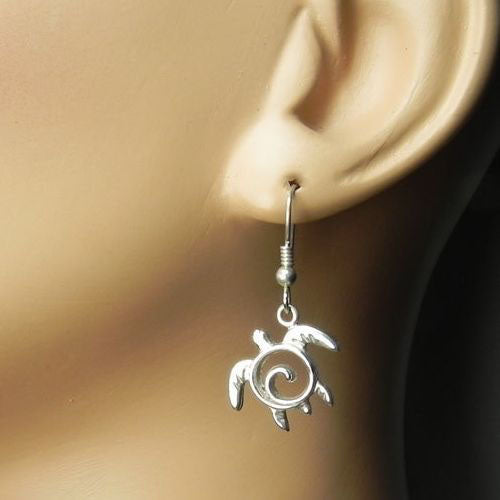 Close-up of a swirl-patterned silver sea turtle earring