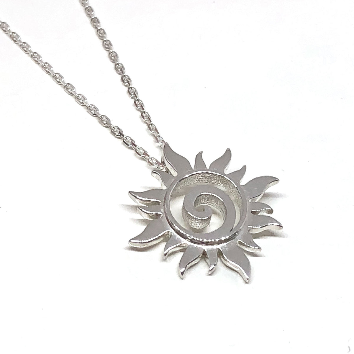 Close-up of the shining silver sun swirl design