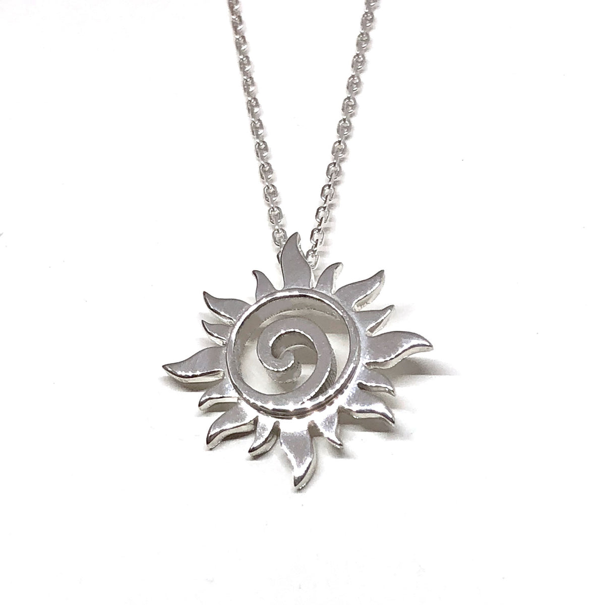 Another angle of the small silver sun pendant on its chain