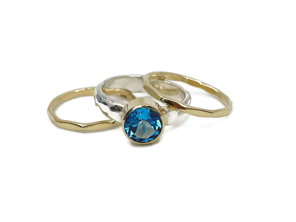 8mm Swiss blue topaz in a yellow gold bezel on a hammered sterling silver stack ring set