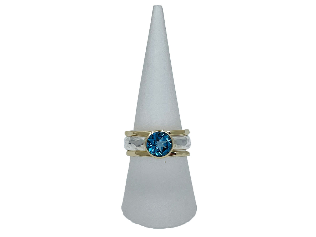 Side view of the blue topaz ring with its hammered silver stack bands