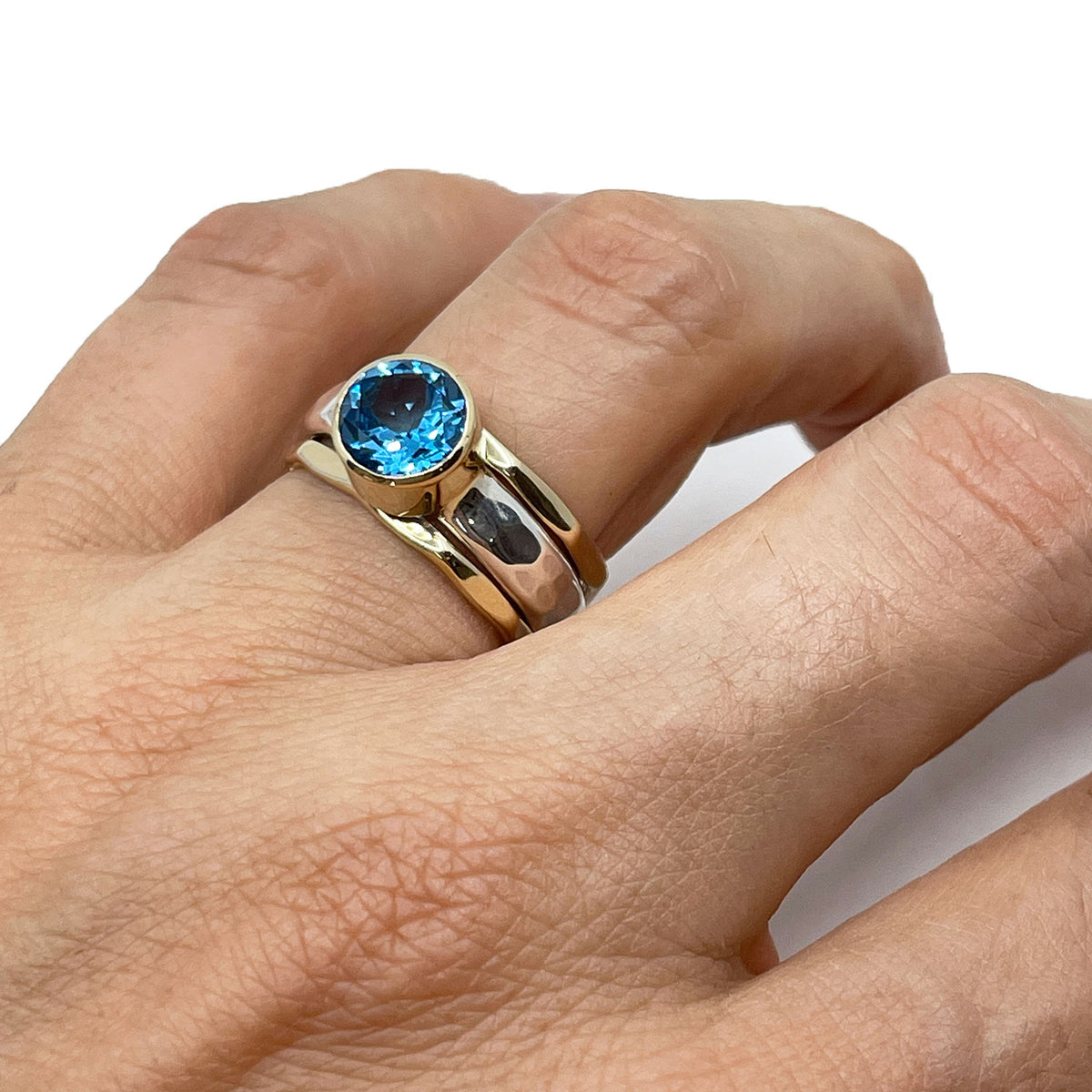 Alternate view of the Swiss blue topaz solitaire stack ring in silver and gold