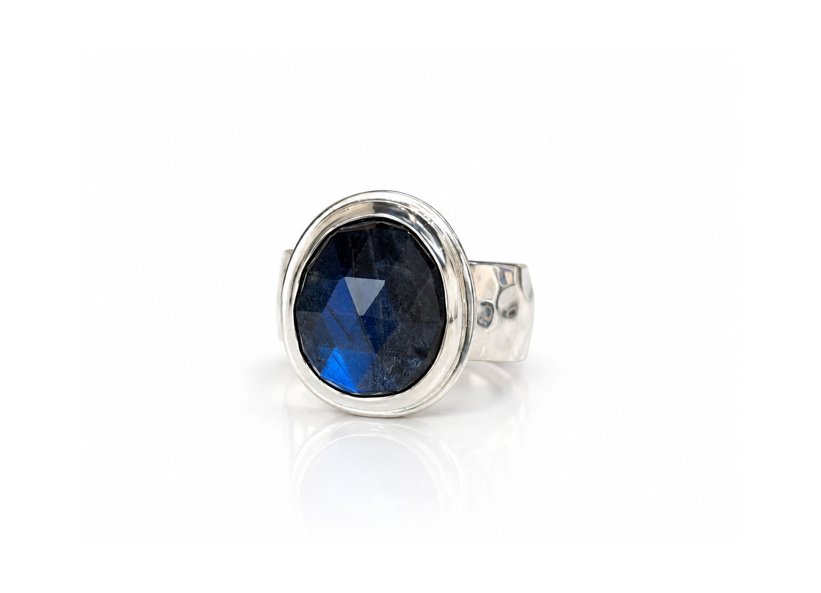 Large faceted oval labradorite with a deep blue flash on an 8mm wide hammered sterling silver band