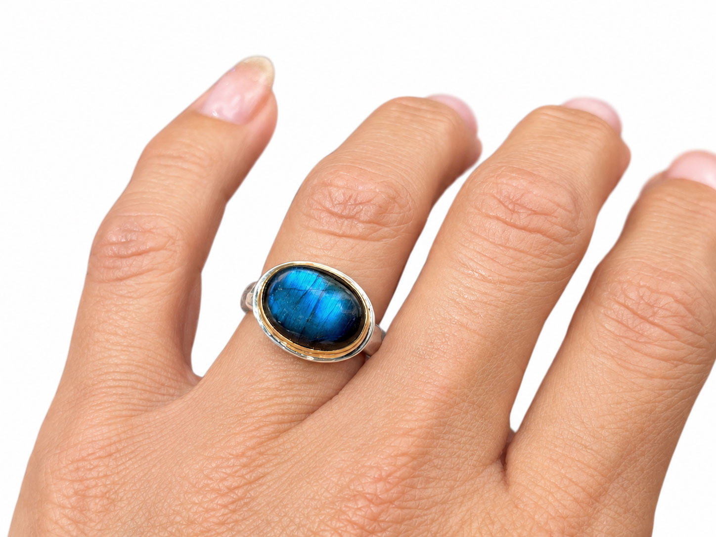 Oval labradorite with a royal blue flash in a 14kt yellow gold bezel on a sterling silver ring